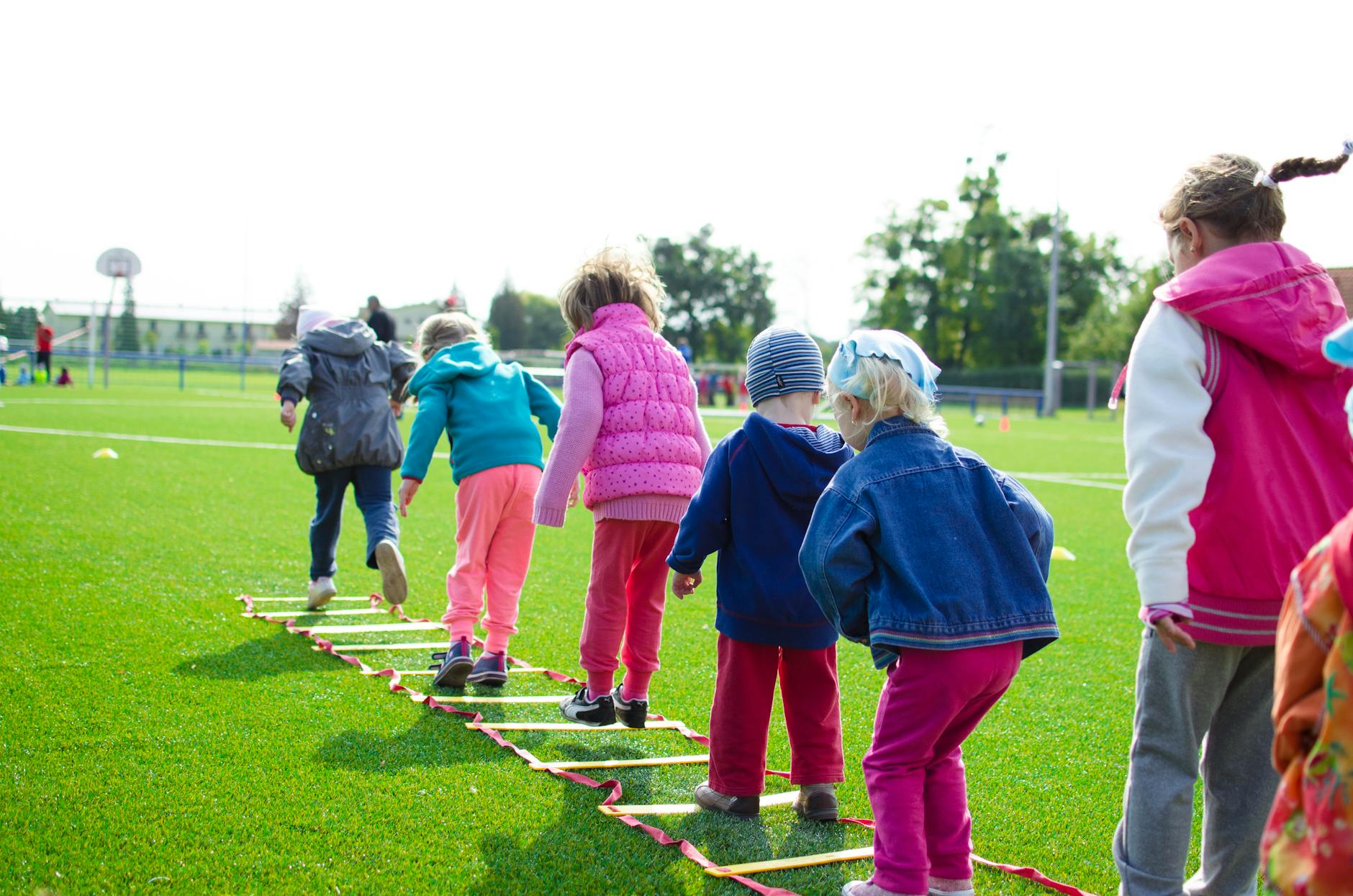 Kids running and playing tag in a neighborhood park during a free outdoor activity on a summer afternoon